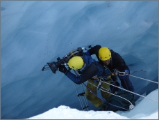 photo of rope access specialist assisting cameraman in ice crevasse in Norway